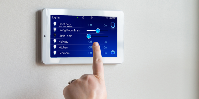 A homeowner changes the lighting settings on an upgraded home security system control panel.